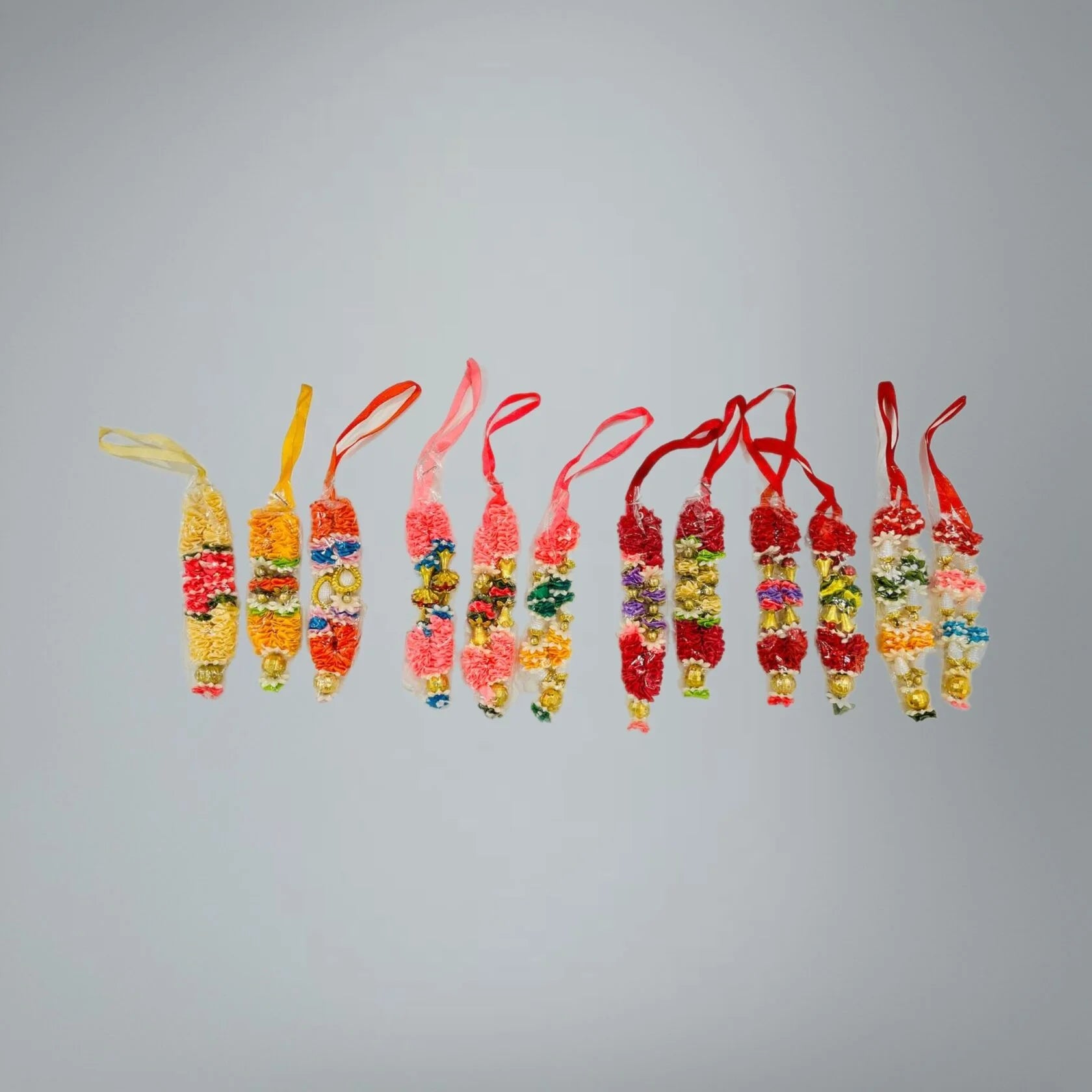 Assorted deity garlands displayed on neutral background - Bhakti Shop